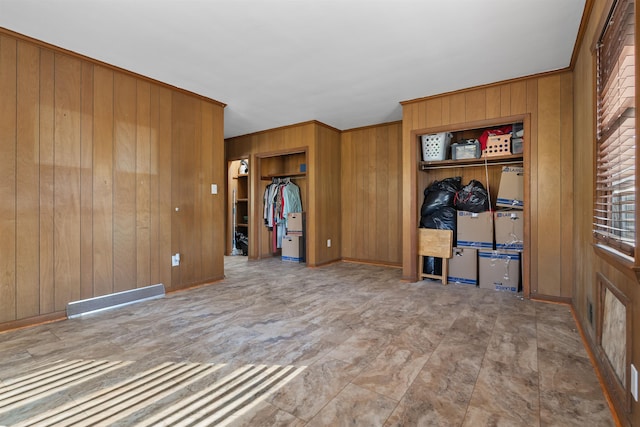 spare room featuring wood walls and crown molding