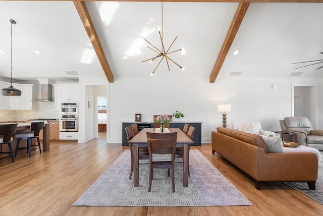 dining space featuring beam ceiling, light hardwood / wood-style flooring, and ceiling fan with notable chandelier