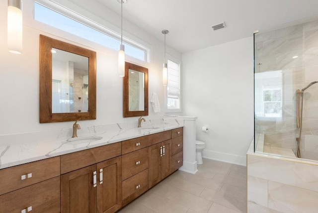 bathroom featuring a tile shower, a wealth of natural light, and vanity