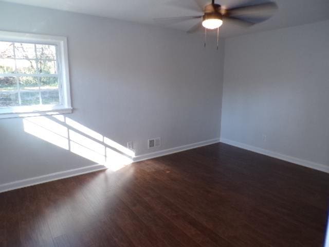 unfurnished room with ceiling fan and dark wood-type flooring