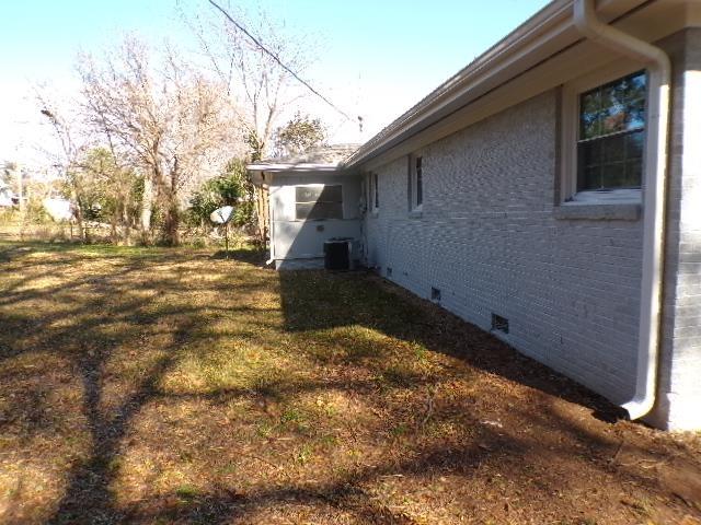 view of property exterior featuring a lawn and central air condition unit