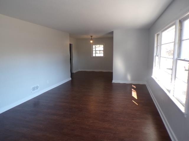 empty room with dark hardwood / wood-style flooring