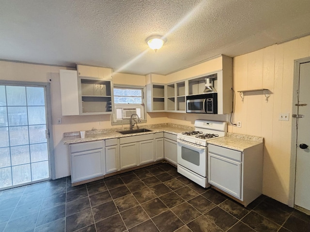 kitchen featuring a textured ceiling, sink, white cabinetry, and white gas range oven