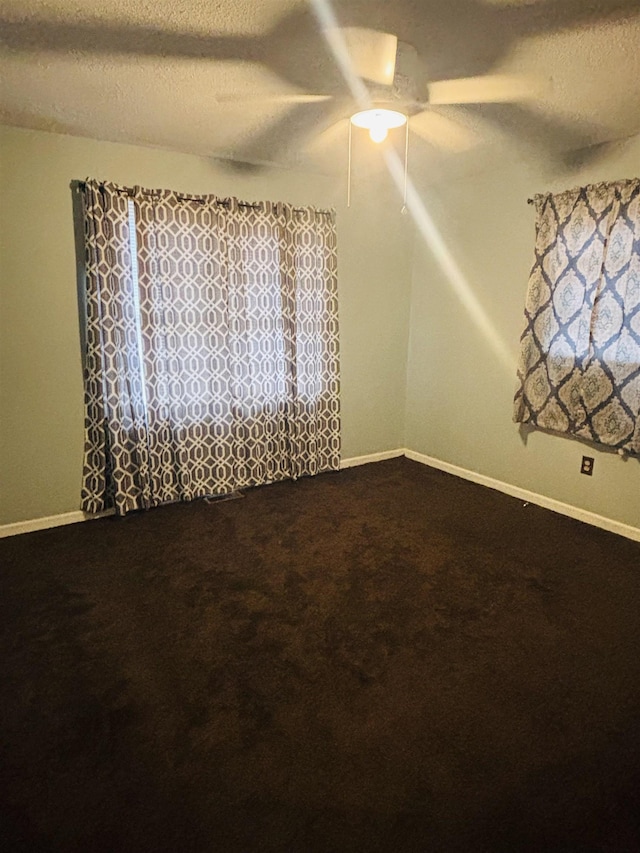 carpeted empty room featuring ceiling fan and a textured ceiling