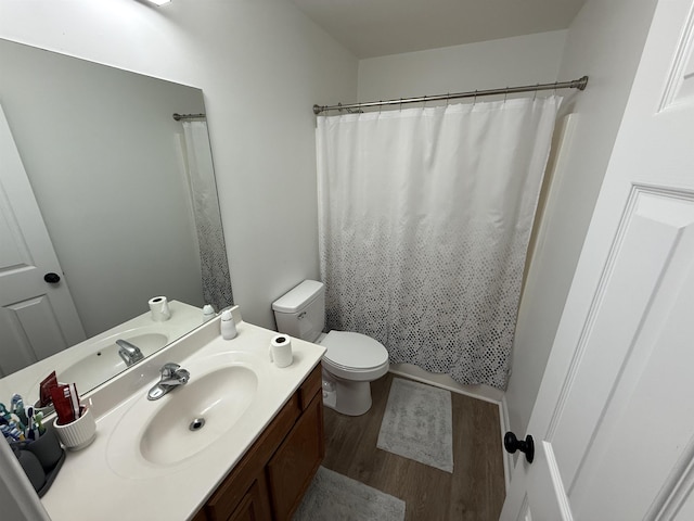 bathroom with a shower with curtain, vanity, wood-type flooring, and toilet