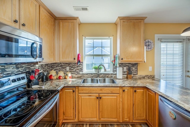 kitchen with backsplash, sink, wood-type flooring, and stainless steel appliances