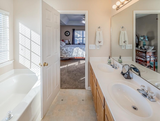 bathroom featuring tile patterned floors, ceiling fan, a bath, and vanity