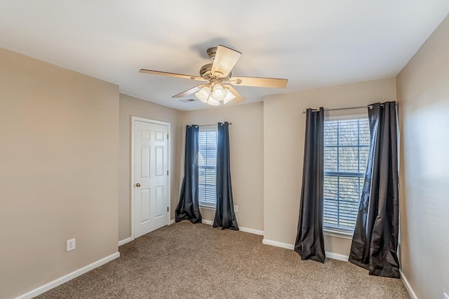 spare room with ceiling fan, light carpet, and a wealth of natural light