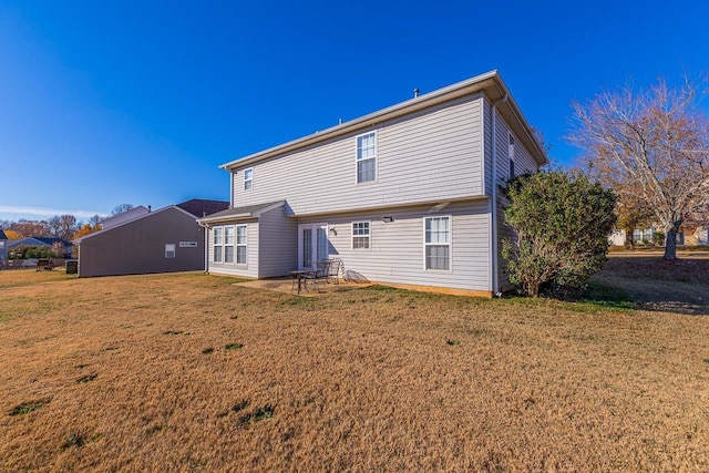 rear view of property with a yard and a patio