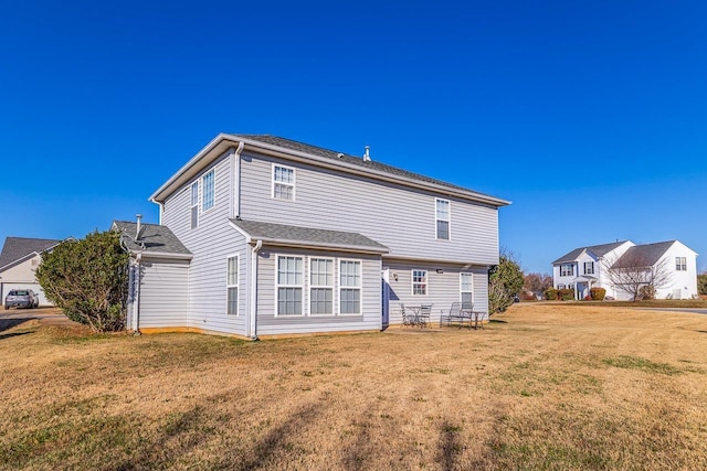 rear view of property featuring a yard