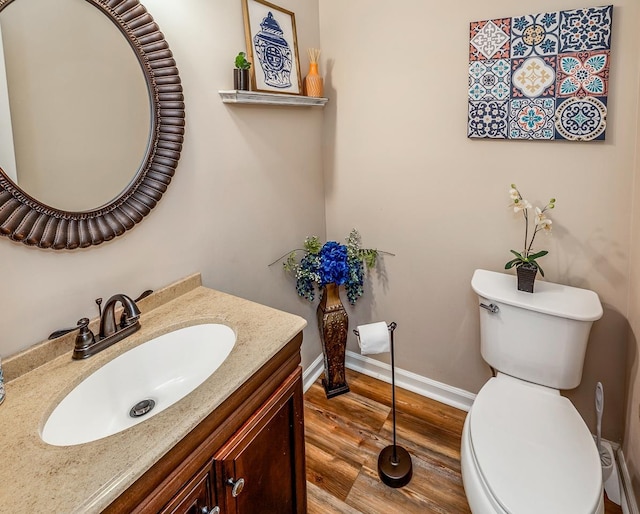 bathroom with hardwood / wood-style floors, vanity, and toilet