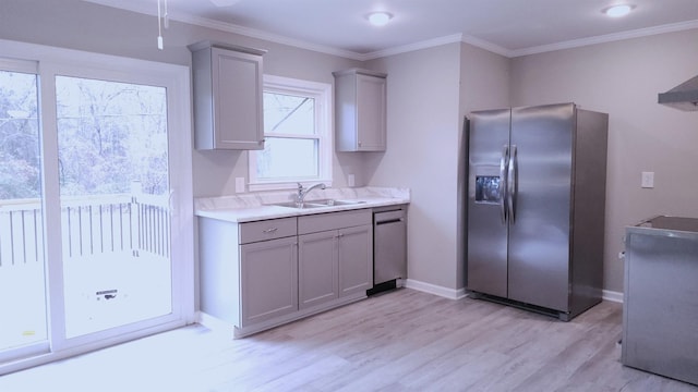 kitchen featuring gray cabinetry, stainless steel appliances, crown molding, sink, and light hardwood / wood-style flooring