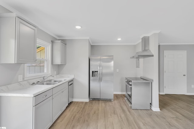 kitchen with sink, stainless steel appliances, light hardwood / wood-style flooring, and wall chimney range hood