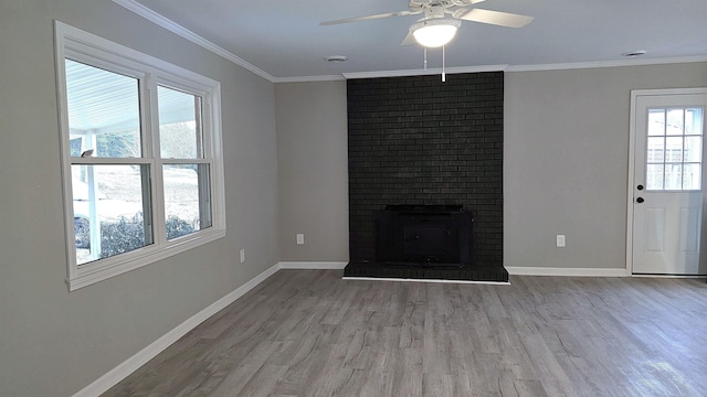 unfurnished living room with a brick fireplace, ceiling fan, crown molding, and light hardwood / wood-style flooring