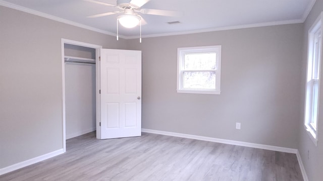 unfurnished bedroom with ceiling fan, a closet, crown molding, and light hardwood / wood-style flooring