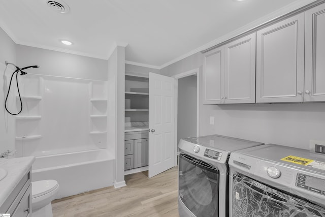 laundry area with separate washer and dryer, crown molding, and light hardwood / wood-style flooring