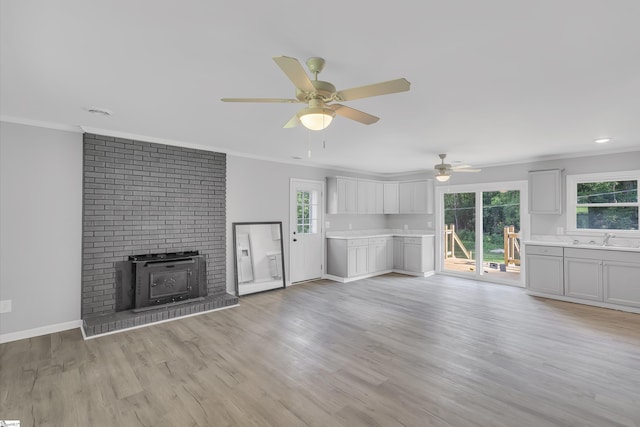 unfurnished living room with plenty of natural light, light hardwood / wood-style floors, and ornamental molding