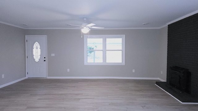 unfurnished living room with light wood-type flooring, a brick fireplace, ceiling fan, and ornamental molding