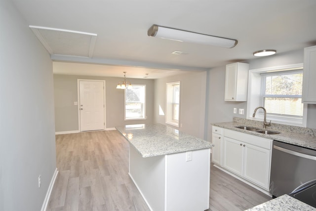 kitchen with white cabinetry, sink, a center island, light hardwood / wood-style flooring, and stainless steel dishwasher