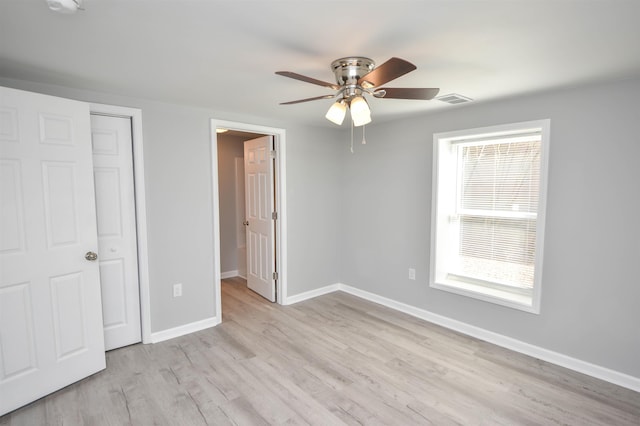 unfurnished bedroom with ceiling fan, light wood-type flooring, and a closet