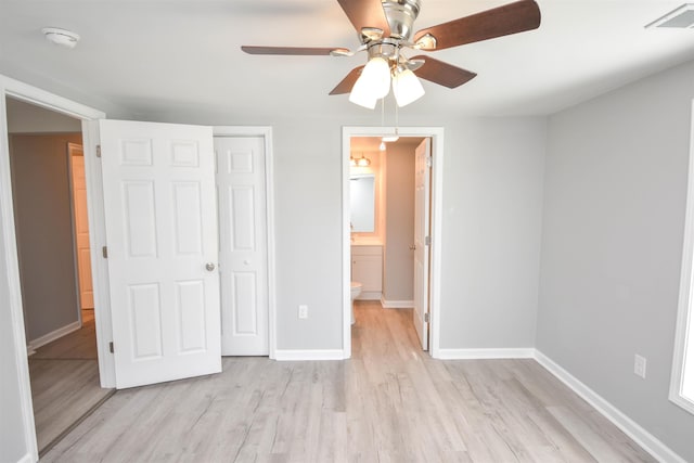 unfurnished bedroom featuring light wood-type flooring, a closet, ensuite bath, and ceiling fan