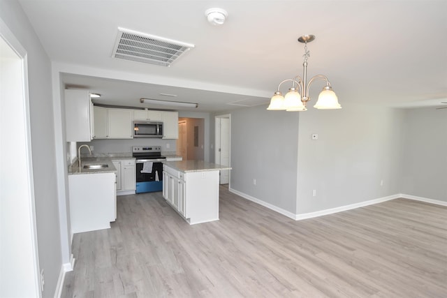 kitchen with decorative light fixtures, a kitchen island, white cabinetry, and appliances with stainless steel finishes