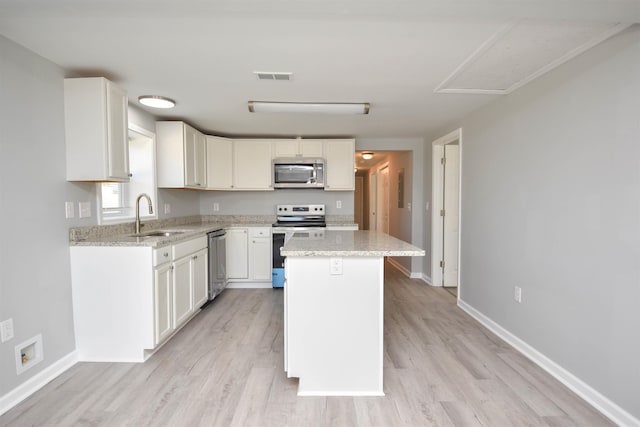 kitchen with white cabinetry, sink, a center island, and stainless steel appliances