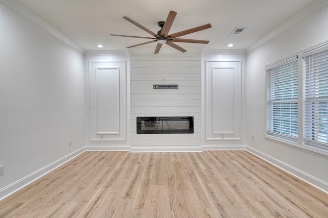 unfurnished living room featuring a fireplace, light wood-type flooring, ceiling fan, and crown molding