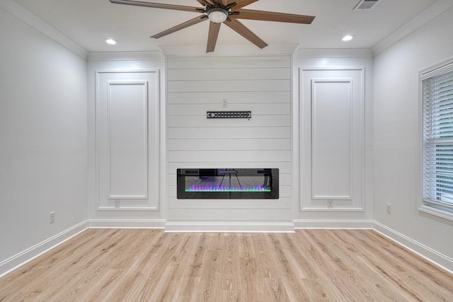 unfurnished living room with ceiling fan, crown molding, light wood-type flooring, and a fireplace