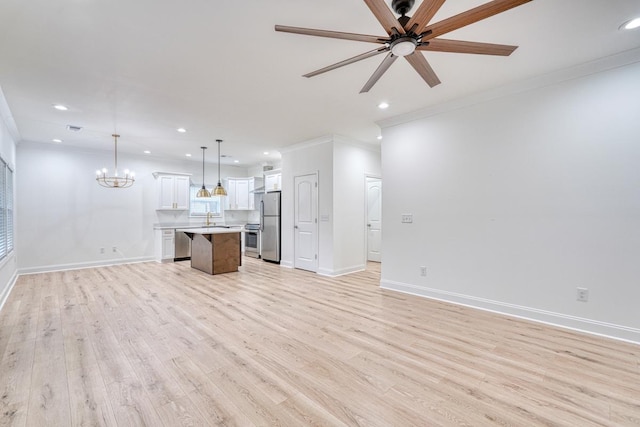 unfurnished living room featuring ceiling fan with notable chandelier, light hardwood / wood-style floors, ornamental molding, and sink