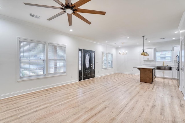 foyer with ceiling fan with notable chandelier, light hardwood / wood-style flooring, a healthy amount of sunlight, and sink