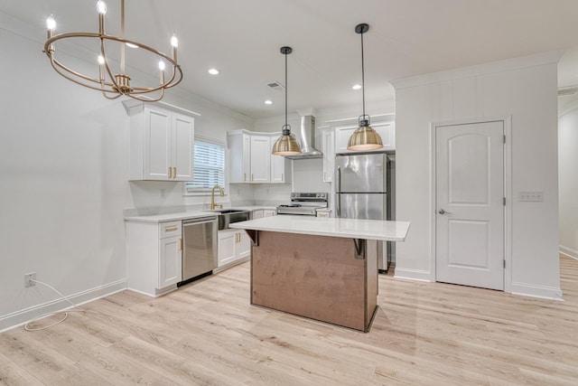 kitchen with decorative light fixtures, a center island, white cabinetry, and stainless steel appliances