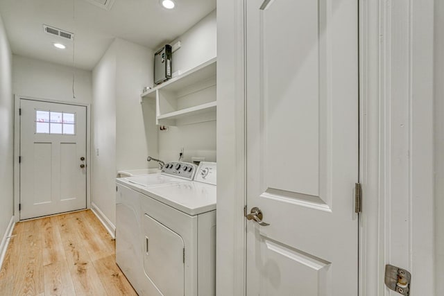 laundry room featuring washer and dryer and light wood-type flooring