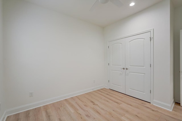 unfurnished bedroom with light wood-type flooring, a closet, and ceiling fan