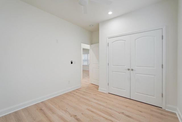 unfurnished bedroom featuring ceiling fan, light hardwood / wood-style floors, and a closet