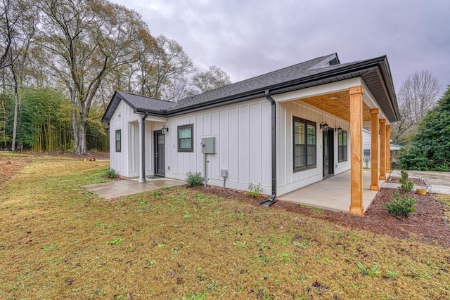 rear view of house featuring a lawn and a patio area