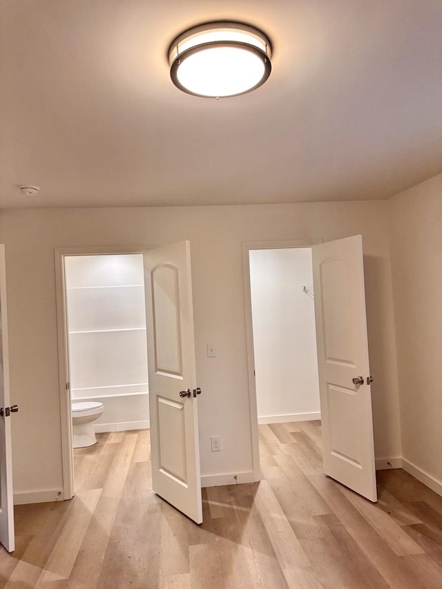 interior space with connected bathroom and light hardwood / wood-style flooring