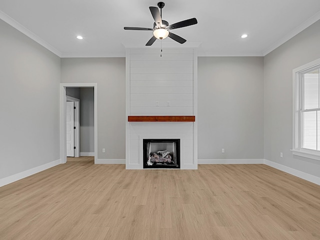 unfurnished living room with crown molding, a fireplace, and light wood-type flooring