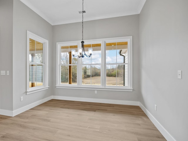 unfurnished dining area featuring light hardwood / wood-style floors, a notable chandelier, and ornamental molding