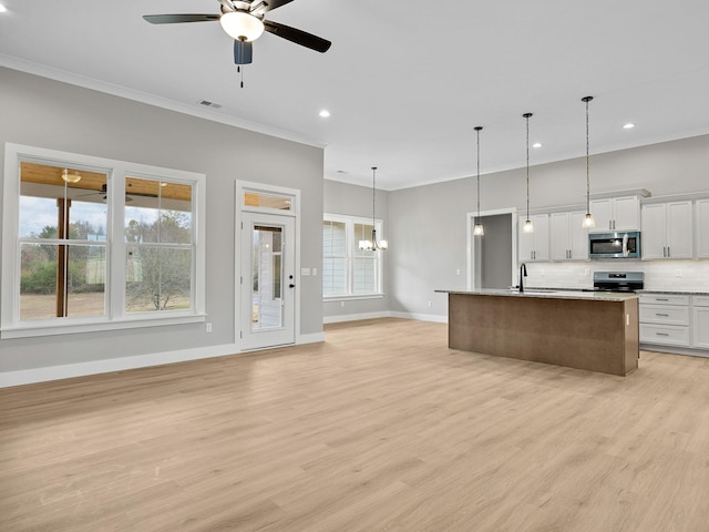 kitchen featuring stainless steel appliances, pendant lighting, light hardwood / wood-style floors, white cabinetry, and an island with sink