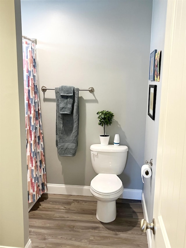 bathroom with hardwood / wood-style floors and toilet