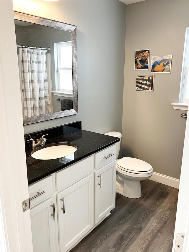 bathroom featuring a shower with curtain, vanity, hardwood / wood-style flooring, and toilet