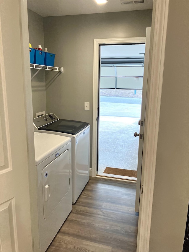 laundry room featuring washing machine and dryer and wood-type flooring