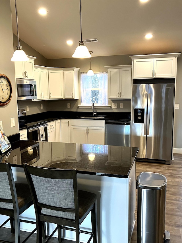 kitchen featuring sink, dark hardwood / wood-style floors, decorative light fixtures, white cabinetry, and stainless steel appliances