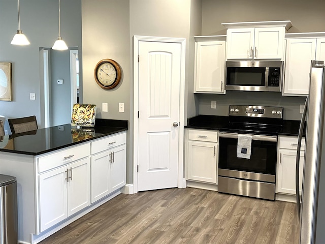 kitchen with appliances with stainless steel finishes, white cabinetry, and wood-type flooring