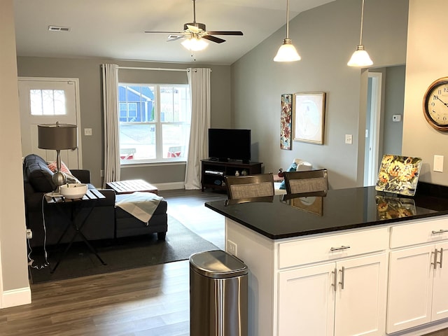 kitchen featuring pendant lighting, lofted ceiling, dark wood-type flooring, ceiling fan, and white cabinetry