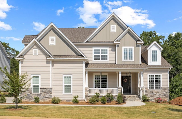 craftsman-style home featuring covered porch and a front lawn