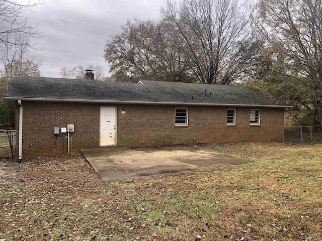 back of property featuring a lawn and a patio area