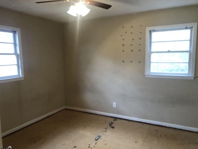 empty room featuring ceiling fan and plenty of natural light