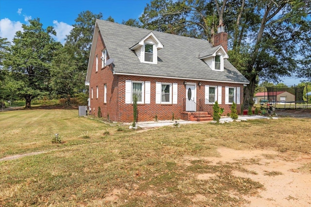 cape cod home featuring central AC unit and a front yard